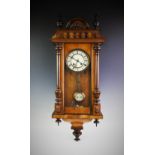 A late Victorian Vienna walnut wall clock, the architectural case with turned columns and finials