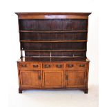 A George III oak high back Welsh dresser, with a moulded cornice above a plain frieze and three