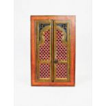 A painted Indian hardwood hanging corner cupboard, the openwork carved doors enclosing a vacant