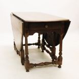 An 18th century oak oval drop leaf dining table, on block and turned legs with conforming cross