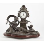 OROLOGIO in metallo brunito con figura allegorica. XX secolo Misure: cm 50 x 20 x h 40