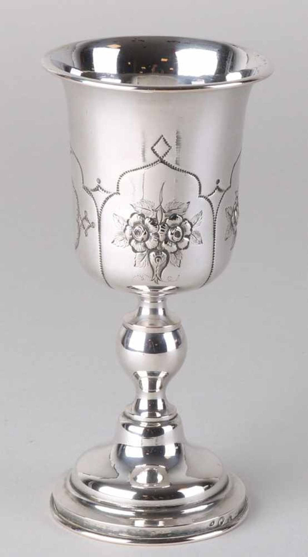 Silver chalice with flower decoration and a trembled line of lines, placed on a round base with