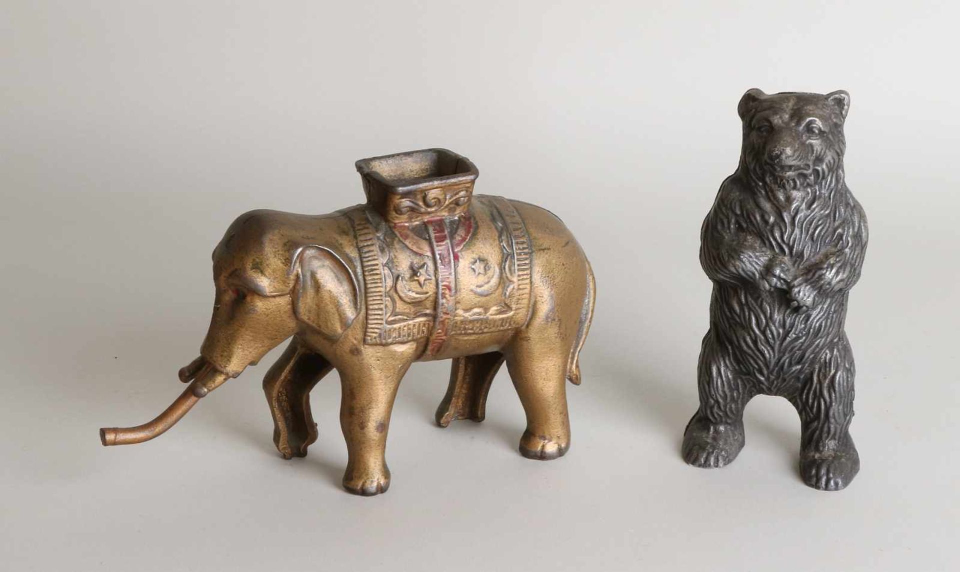 Two old cast-iron money boxes. Consisting of: Bear + Asian elephant. 20th century. Dimensions: