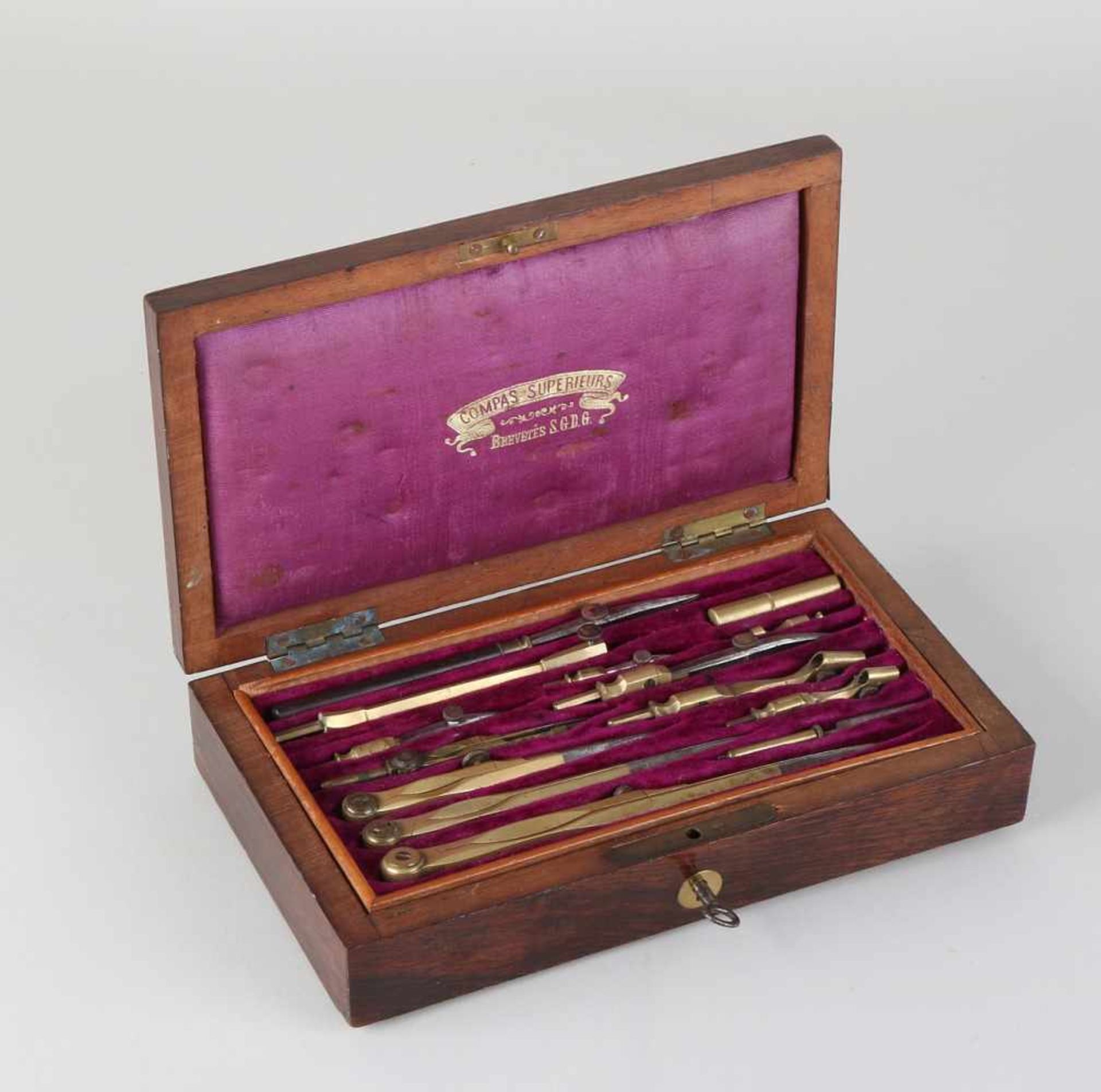 Antique French brass compass set in rosewood box. Fourteen parts. Dimensions: 21 x 12 x 4.5 cm. In