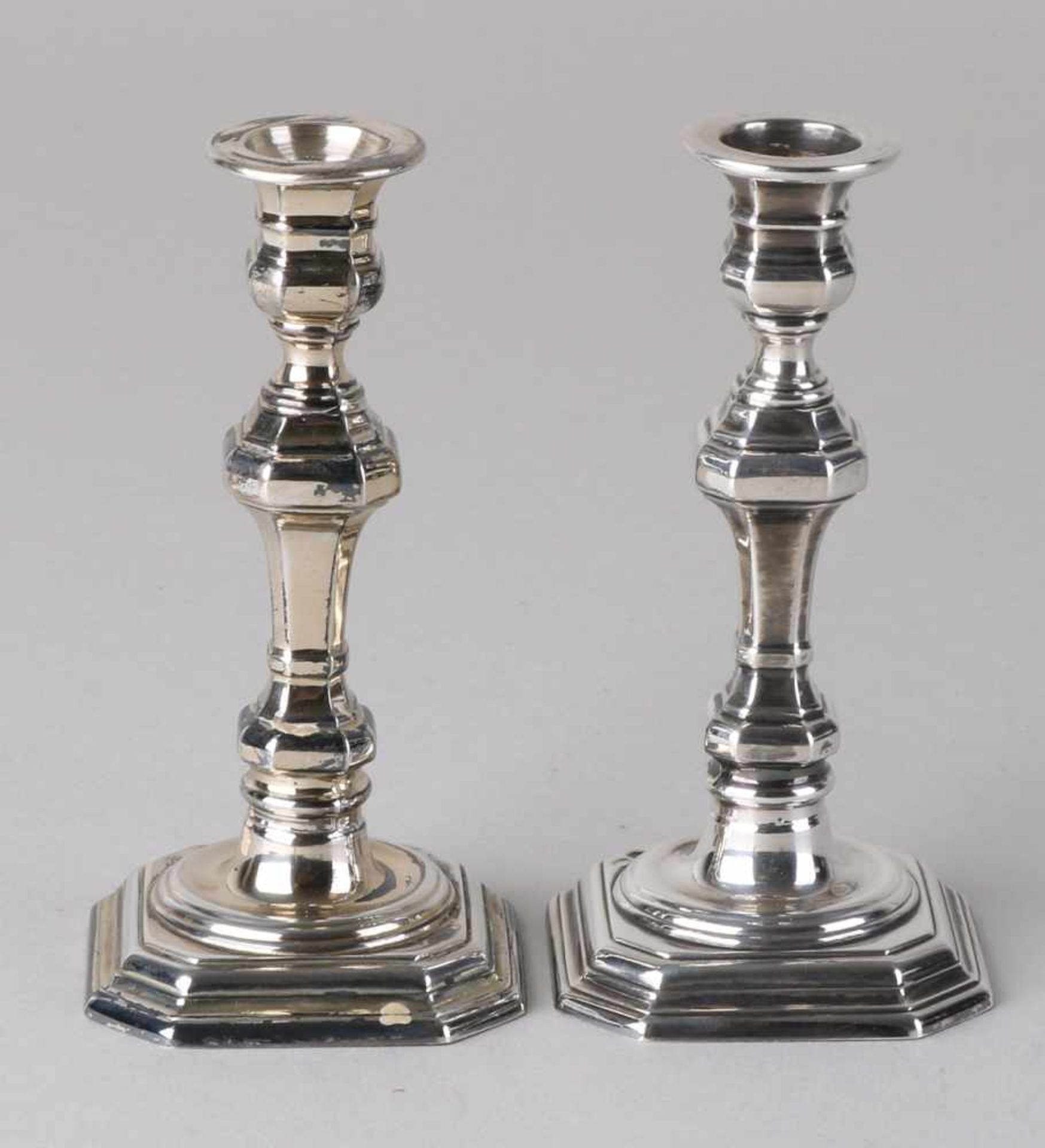 Two small candlesticks, 835/000, on a square contoured base with contoured column and a round light.