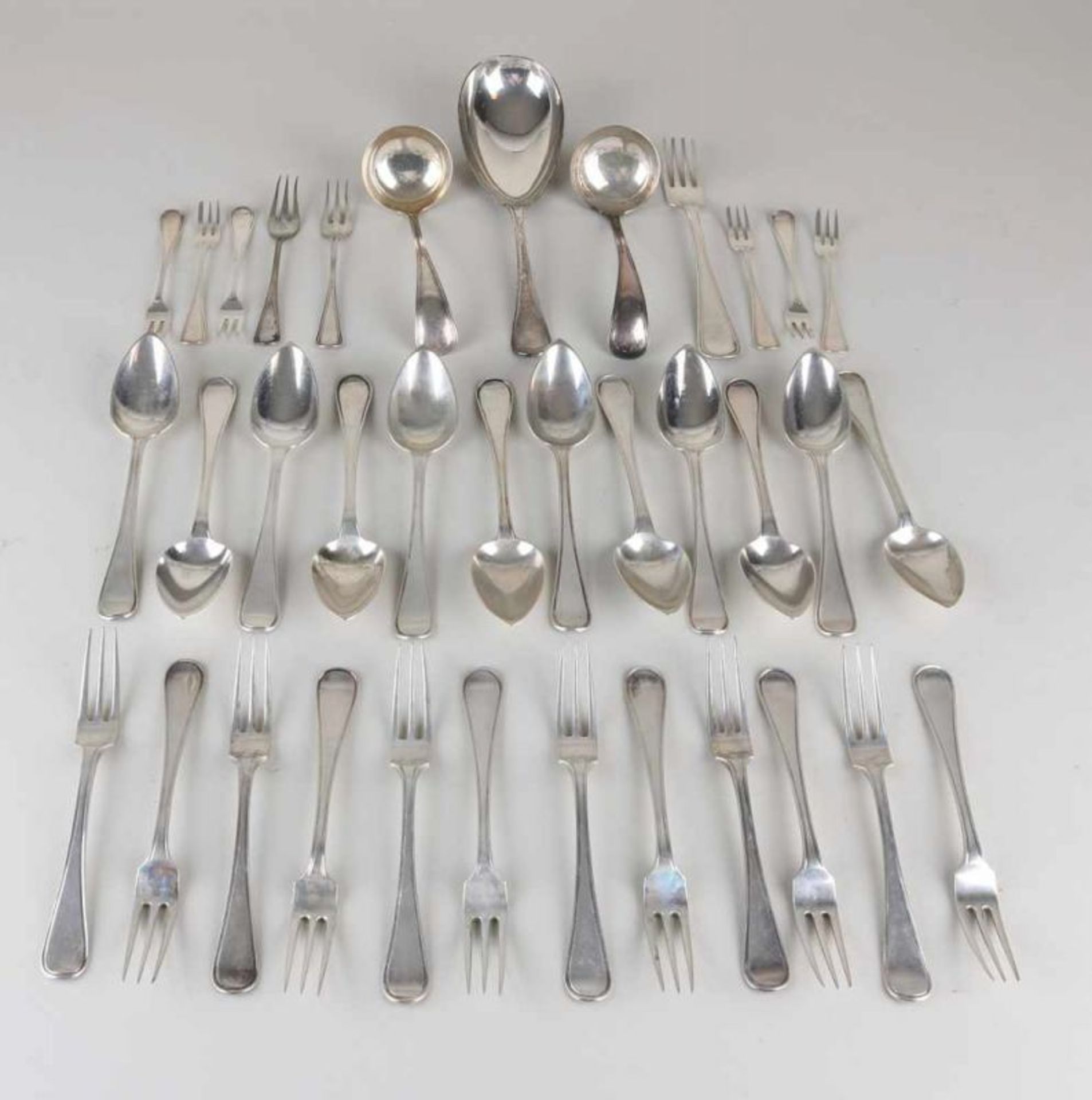 Silver cutlery, 833/000, with 12 forks and spoons, with engraving on the back of the handle, MT .: