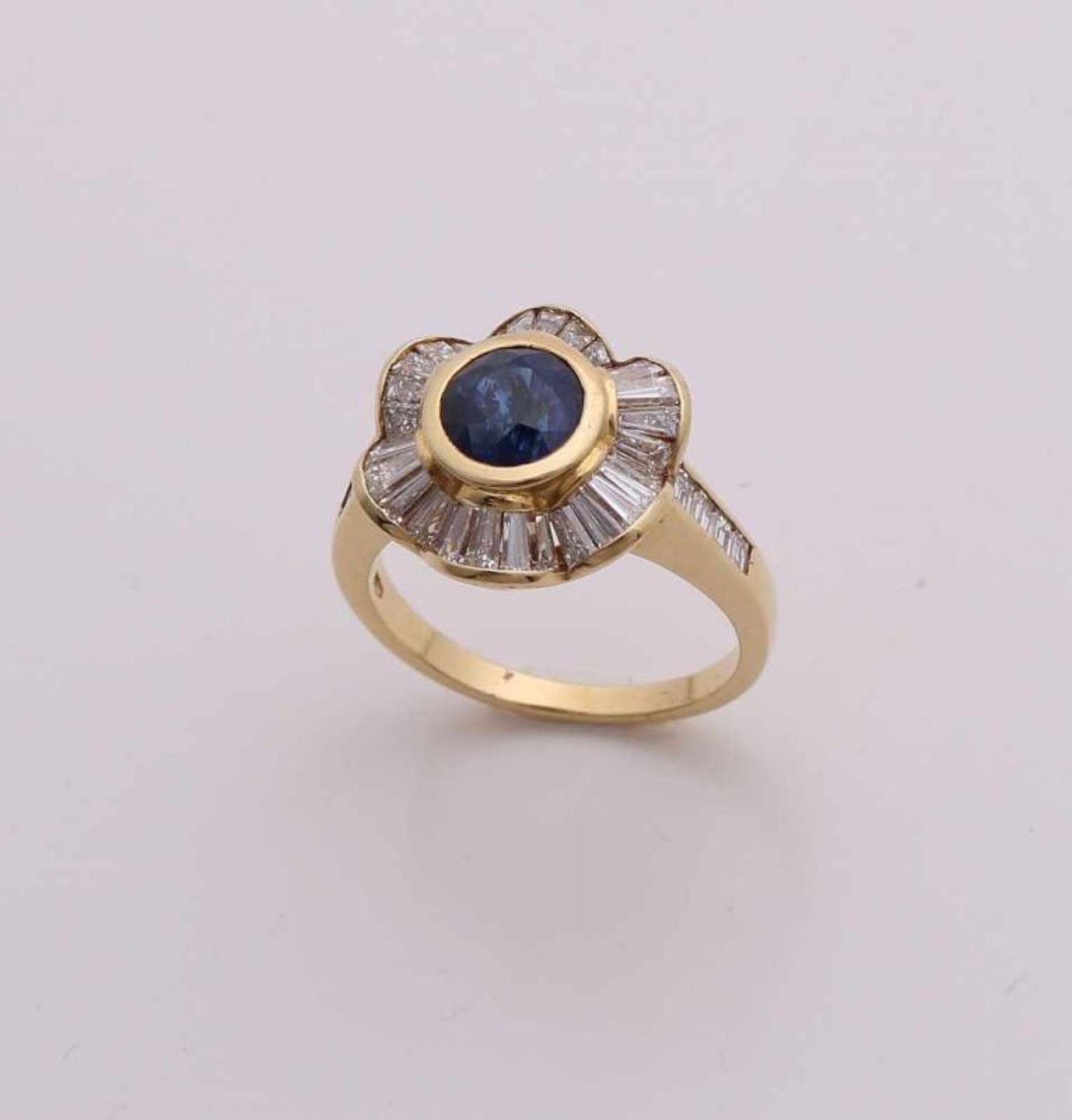 Elegant yellow gold ring, 750/000, with sapphire and diamonds.  The ring has a flower shape with a