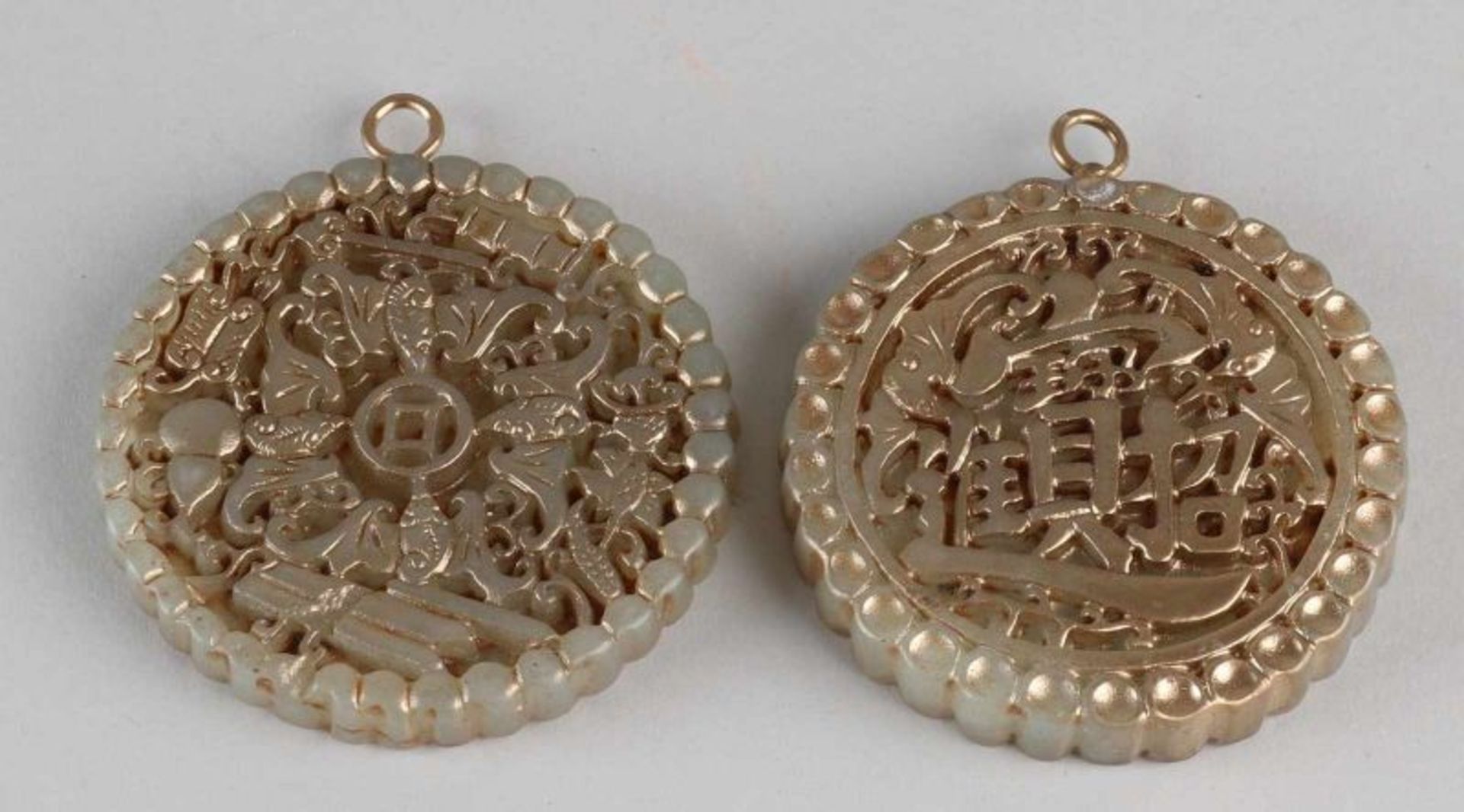 Two old gold-colored Chinese jade amulets with bats etc. Size: 7 - 7.5 cm ø. In good condition.