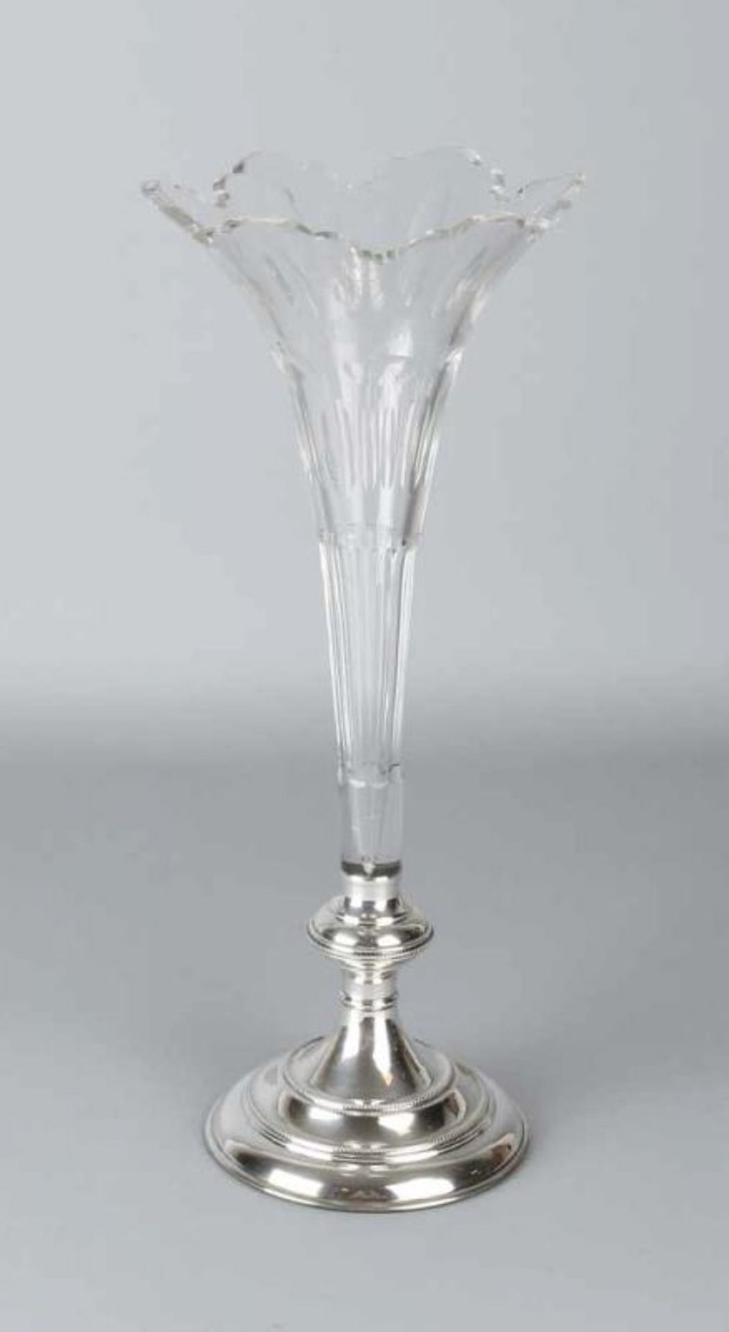 Beautiful crystal vase, Flute, placed on a silver base. Trumpet-shaped crystal vase with a contoured