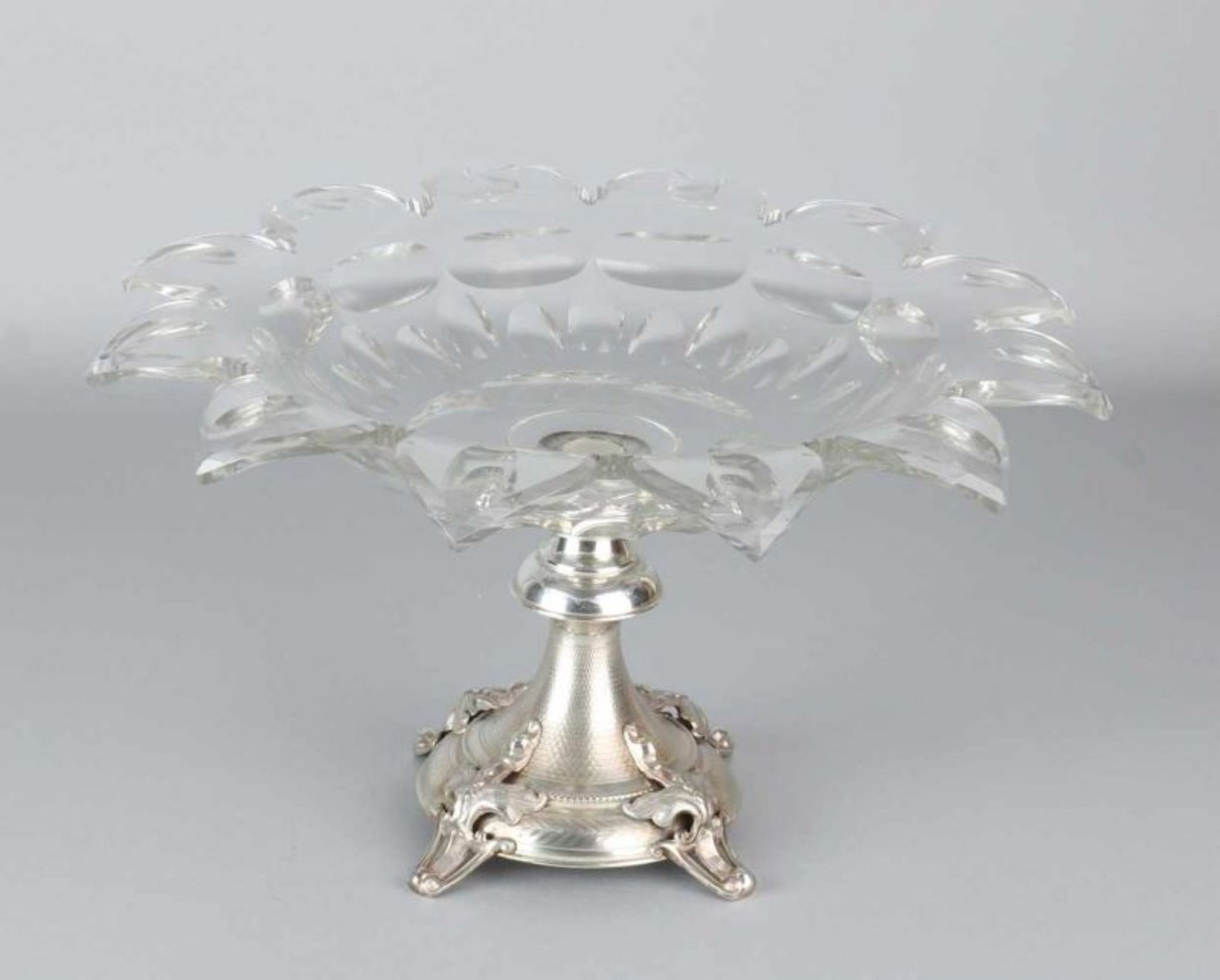 Crystal table piece placed on silver base. Round crystal bowl with turned-over contoured rim with
