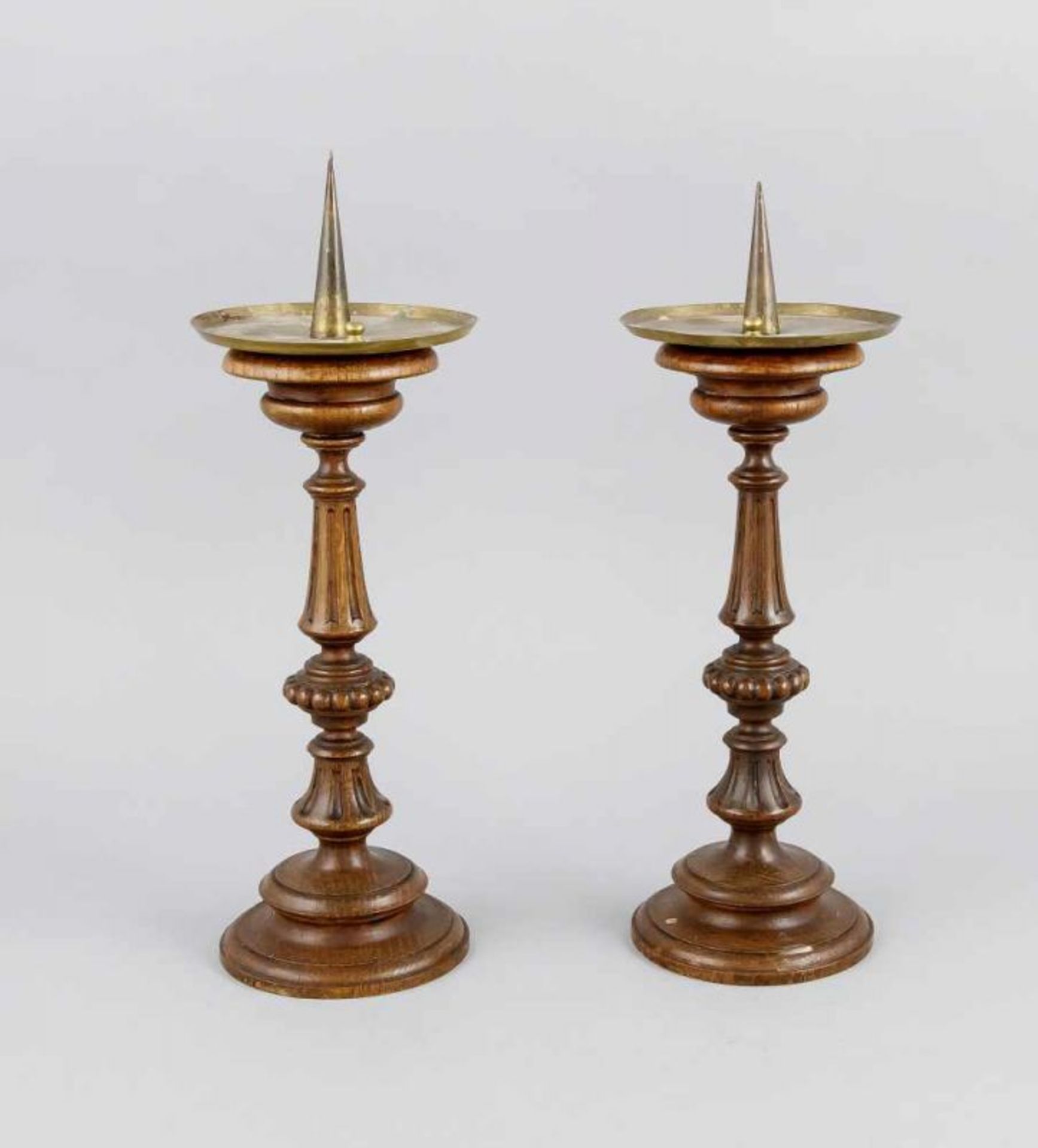 Two 19th century wooden candle holders with brass drip edge. Dimensions: H 36 cm. In good