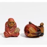 ZWEI NETSUKE: DARUMA UND MANN MIT GROßER MOKUGYÔ-TROMMEL. Japan. 19. Jh. Holz mit Lack. H. 3/3,