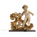 SITZENDER PUTTO AUF VOLUTENKONSOLE. Süddeutschland. Holz, geschnitzt und farbig gefasst. H.42cm.