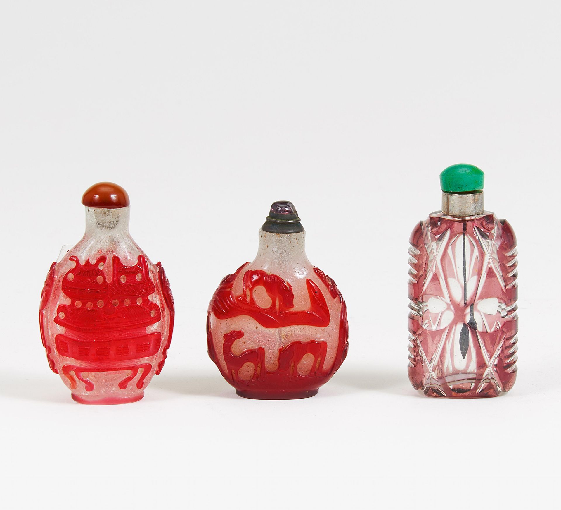 DREI SNUFFBOTTLE. China. Glas mit geschnittenem Überfang. H. 7,3cm, H. 7,9cm, H. 6,6cm. Zustand A/B.