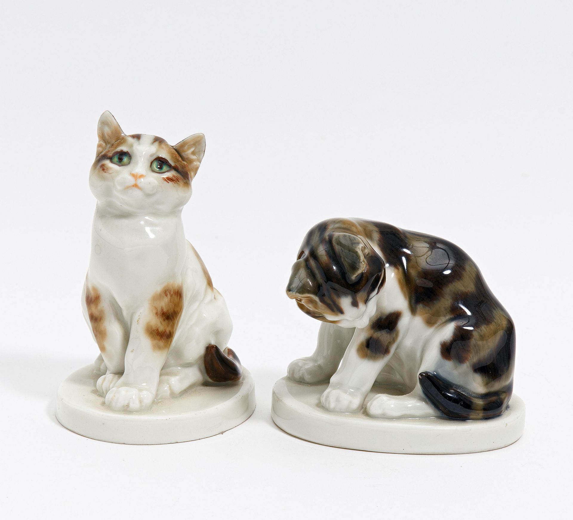 2 KATZEN. Meissen. Modell E. Hösel, 1917. Porzellan, farbiges Dekor. Höhe 7,5cm/10,5cm.