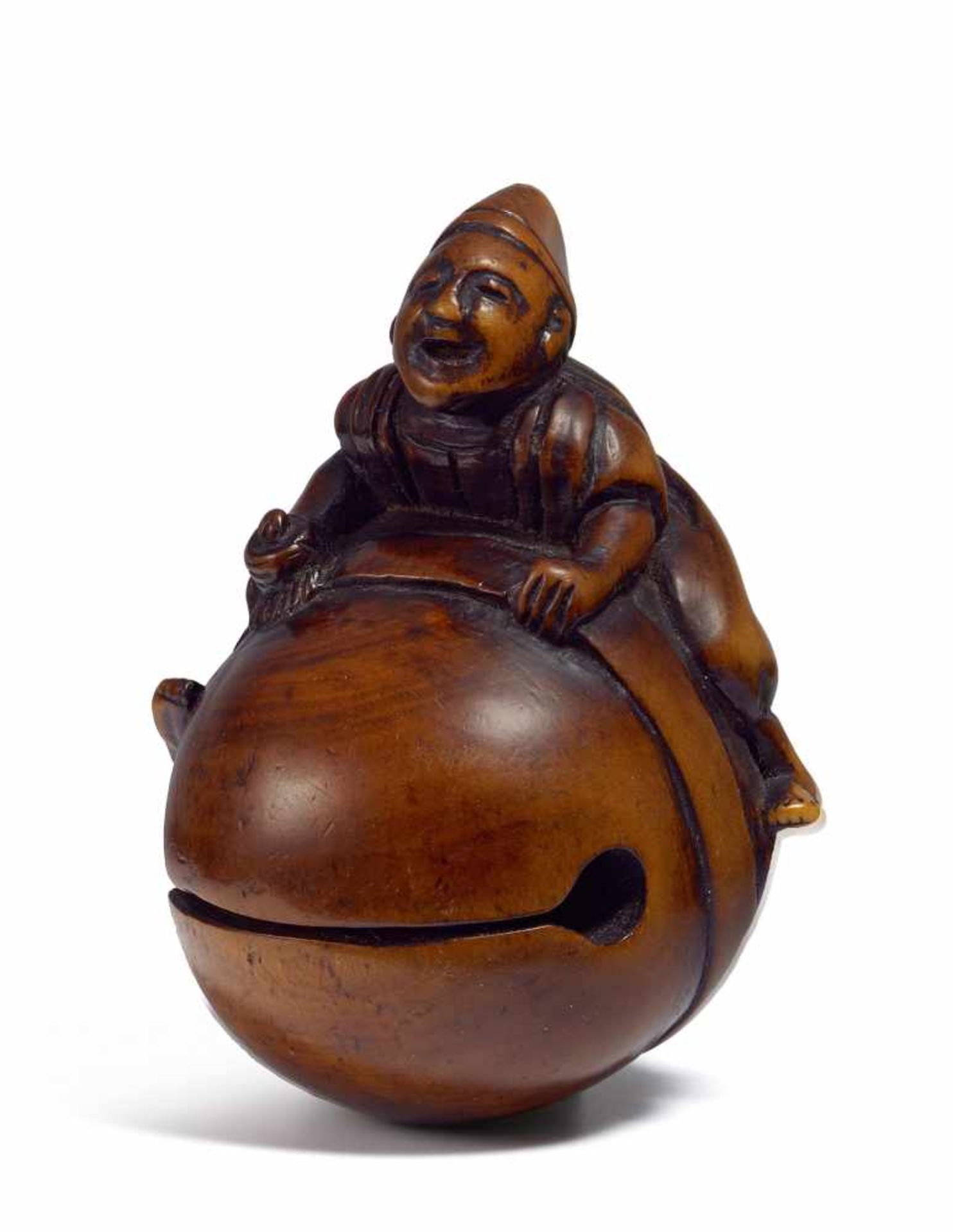 NETSUKE: SHINTÔ-PRIESTER AUF RIESIGER MOKUGYO. Japan. Edo-Zeit. 18. Jh. Buchsbaum. Breitbeinig auf