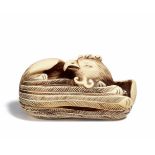 NETSUKE: LIEGENDER HÔÔ-VOGEL. Japan. Meiji-Zeit. Maritimes Elfenbein. Länge 5cm. Sign.: Gyokuzan.