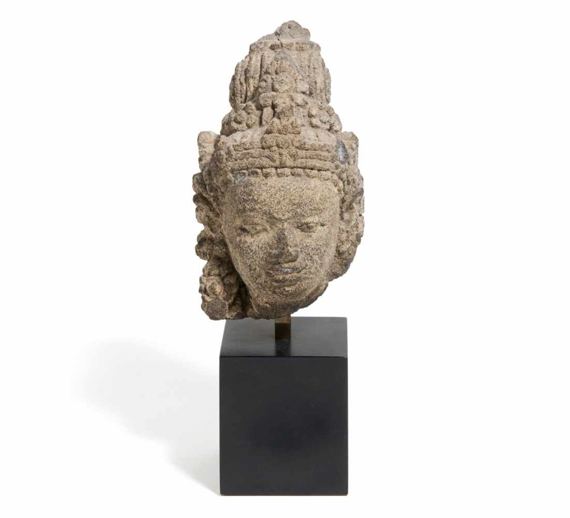 KLEINER KOPF EINES BODHISATTVA. Indo-Javanisch. Ca. 10. Jh. Sandstein. Höhe 15cm. Auf einem Sockel