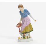 PORCELAIN FIGURE OF A GIRL FEEDING CHICKEN. Meissen. Model A. König. Porcelain, colour enriched.