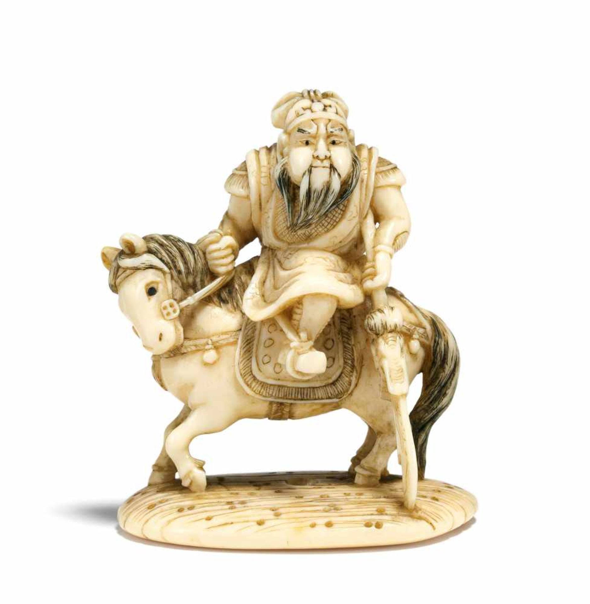 NETSUKE: KAN'U WITH HIS HALBERD 'GREEN DRAGON' RIDING A HORSE. Japan. 19th c. Ivory finely carved