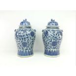 stel Chinees porseleinen dekselvazen met blauw/wit decor van pioenrozen en bekroond door Fo-hond,