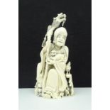 Chinese gestoken ivoren sculptuur met voorstelling van wijsgeer met staf en foo hond, circa 1920, h.