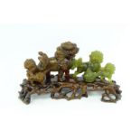 gestoken jade sculptuur met voorstelling van foo honden, rustend op bijpassende gestoken houten