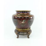 Japanse cloisonné vaas met decor van draken, paradijsvogels en florale motieven, rustend op houten