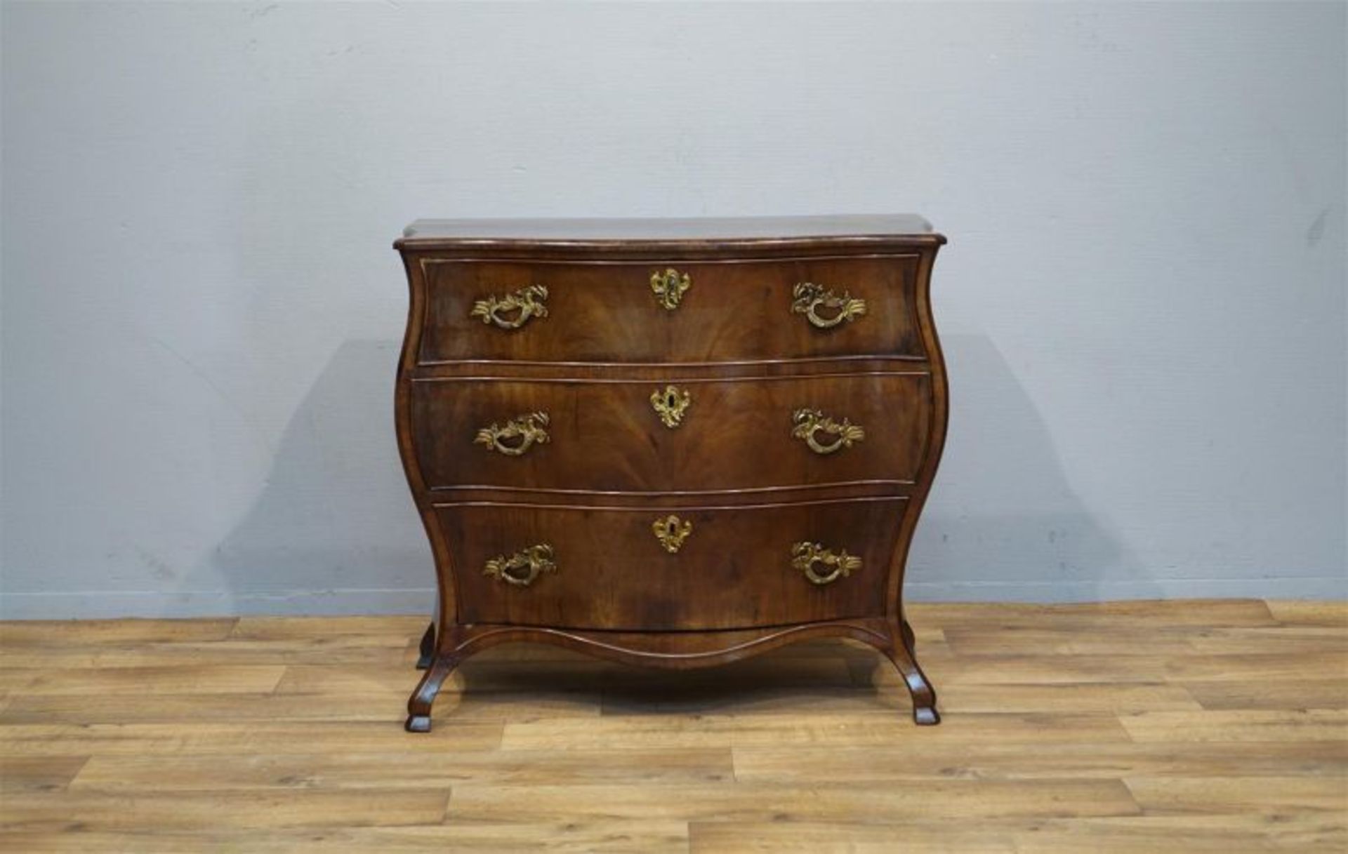 Haagse mahonie Louis XV commode met gecontourneerd blad waaronder 3 lades met verguld bronzen beslag