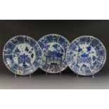 3 blauw/wit Chinees porseleinen schotels met decor van bloemen bij hek, Kangxi, 18e eeuw, diam. 26-