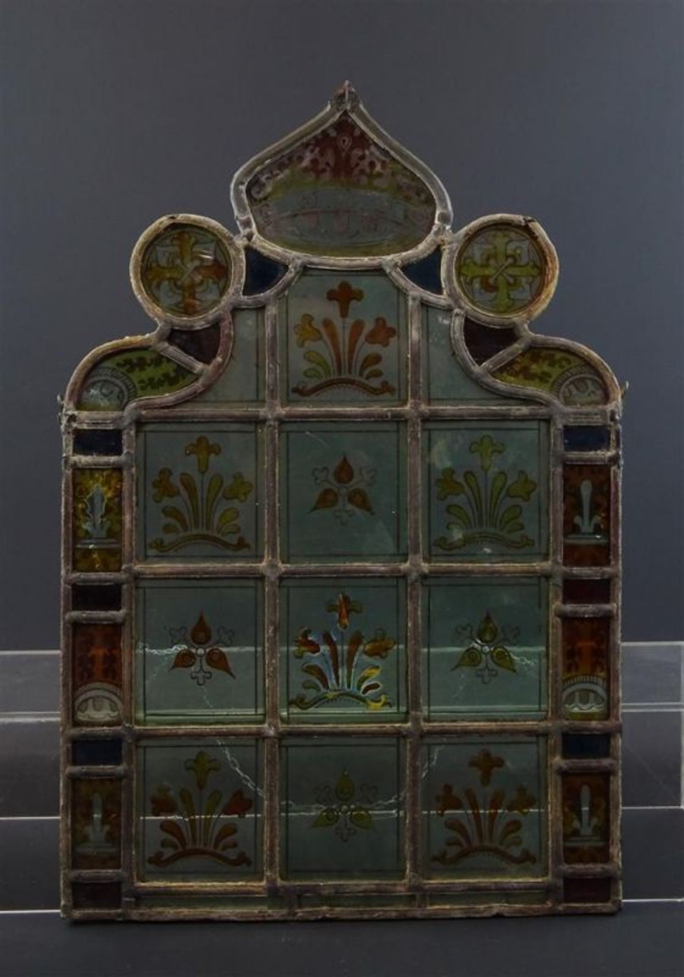 antiek glas-in-lood raam versierd met florale ornamenten en voorzien van gecontourneerde