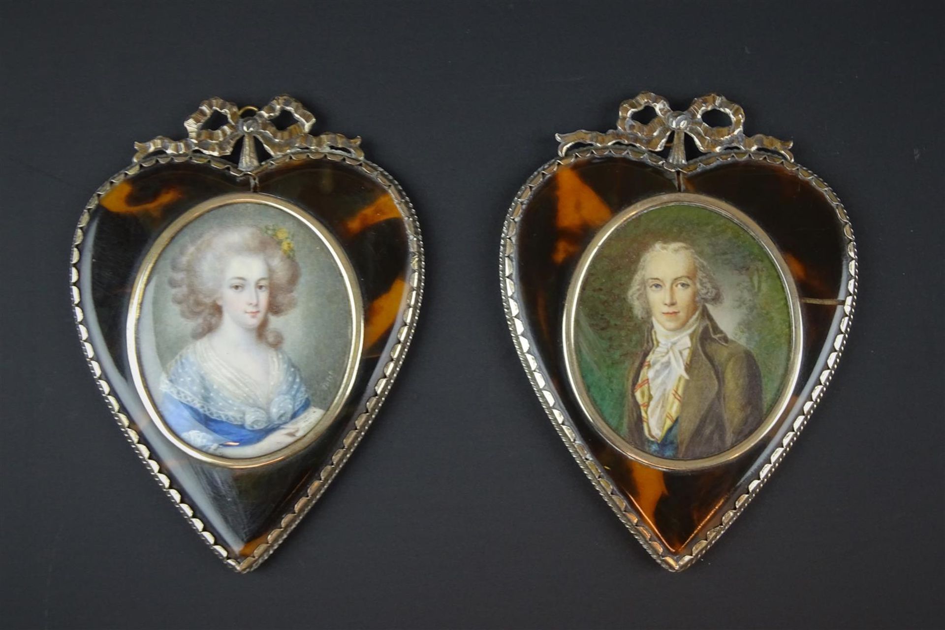 2 portretminiaturen met voorstelling van dame en heer, voorzien van hartvormig zilveren en schildpad