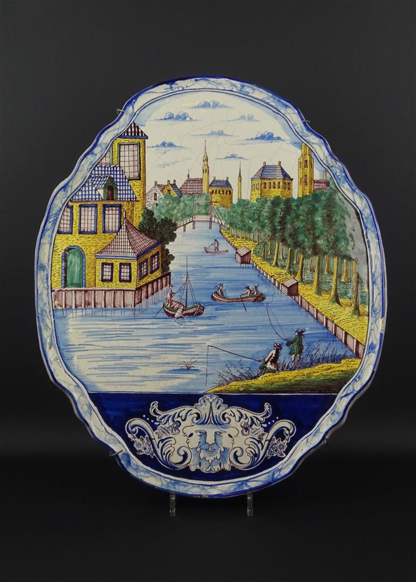 aardewerk plaquette met polychroom decor van een Hollandse stad met vissers, verso gedateerd 1743,
