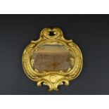 Duits verguld houten Louis XV spiegeltje omlijst door c-voluten, 18e eeuw, h. 29, br. 28- - -29.00 %