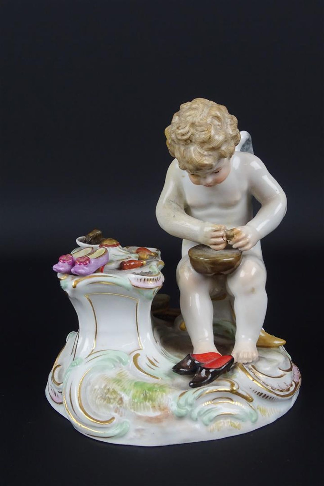 porseleinen sculptuur met voorstelling van schoenmakende putto, gemerkt: Meissen, 19e eeuw, h. 12 cm