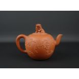 Chinese terracotta Yixing trekpot met reliëfdecor en dekselknop met voorstelling van foo-hond, 1e