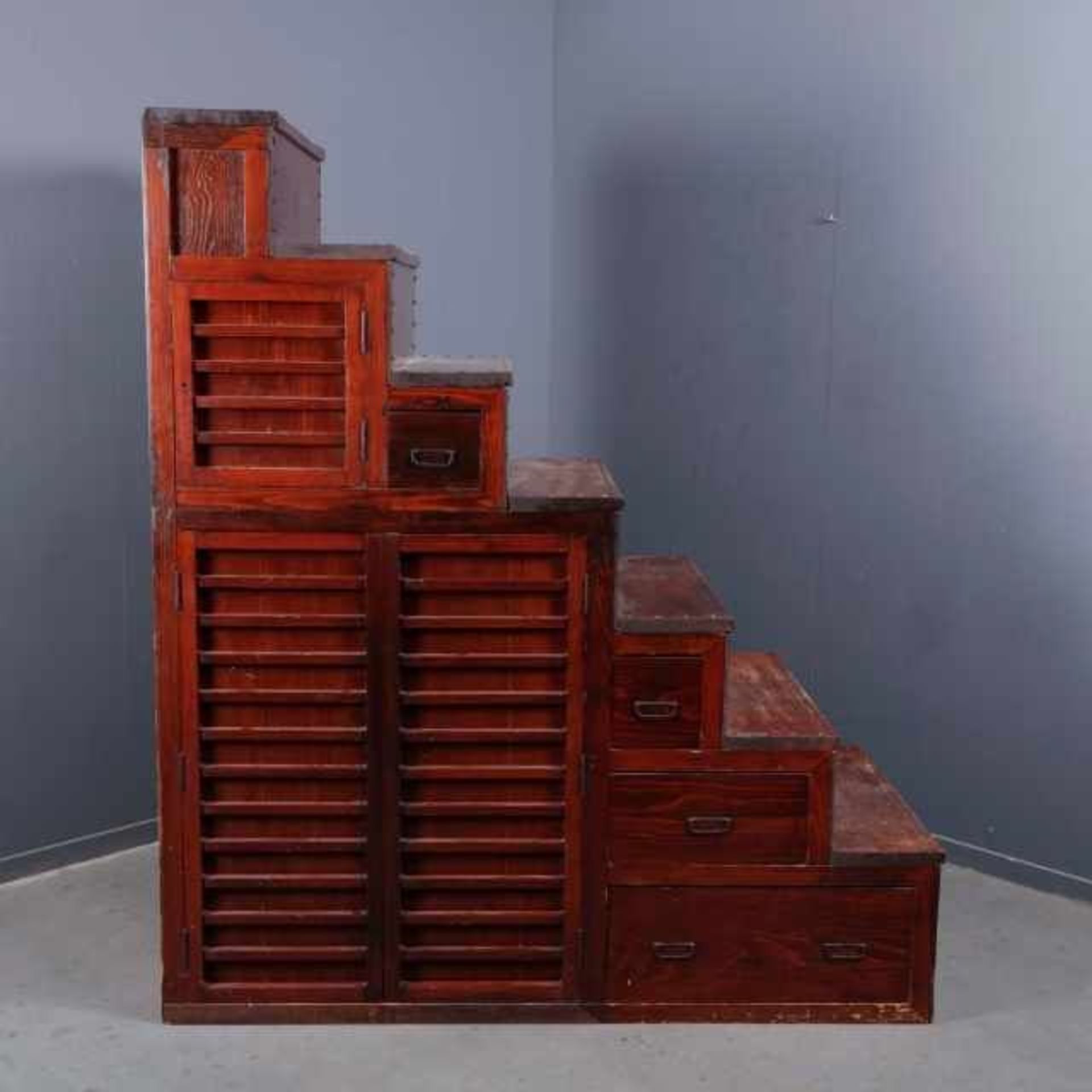 Red stained softwood kaidan-dansu with seven steps, the front with four drawers, a double and a