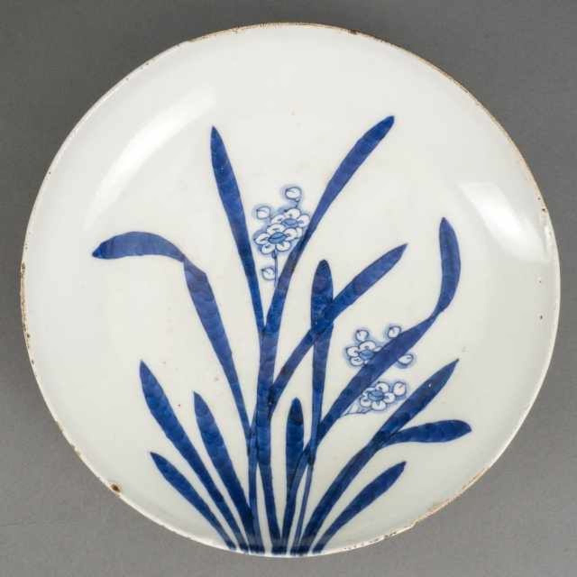 Blue and white Nabeshima-style dish with raised foot and narcissus motif, Japan, the bottom with red