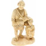 Een ivoren Okimono sculptuur van een man en kind. Japan, begin 20e eeuw.Afm. 13 x 7,5 cm.An ivory