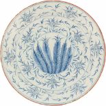 Een aardewerk schotel met bloemen decor. Ca. 1800.Randschade. Ø 33,5 cm.An earthenware dish with