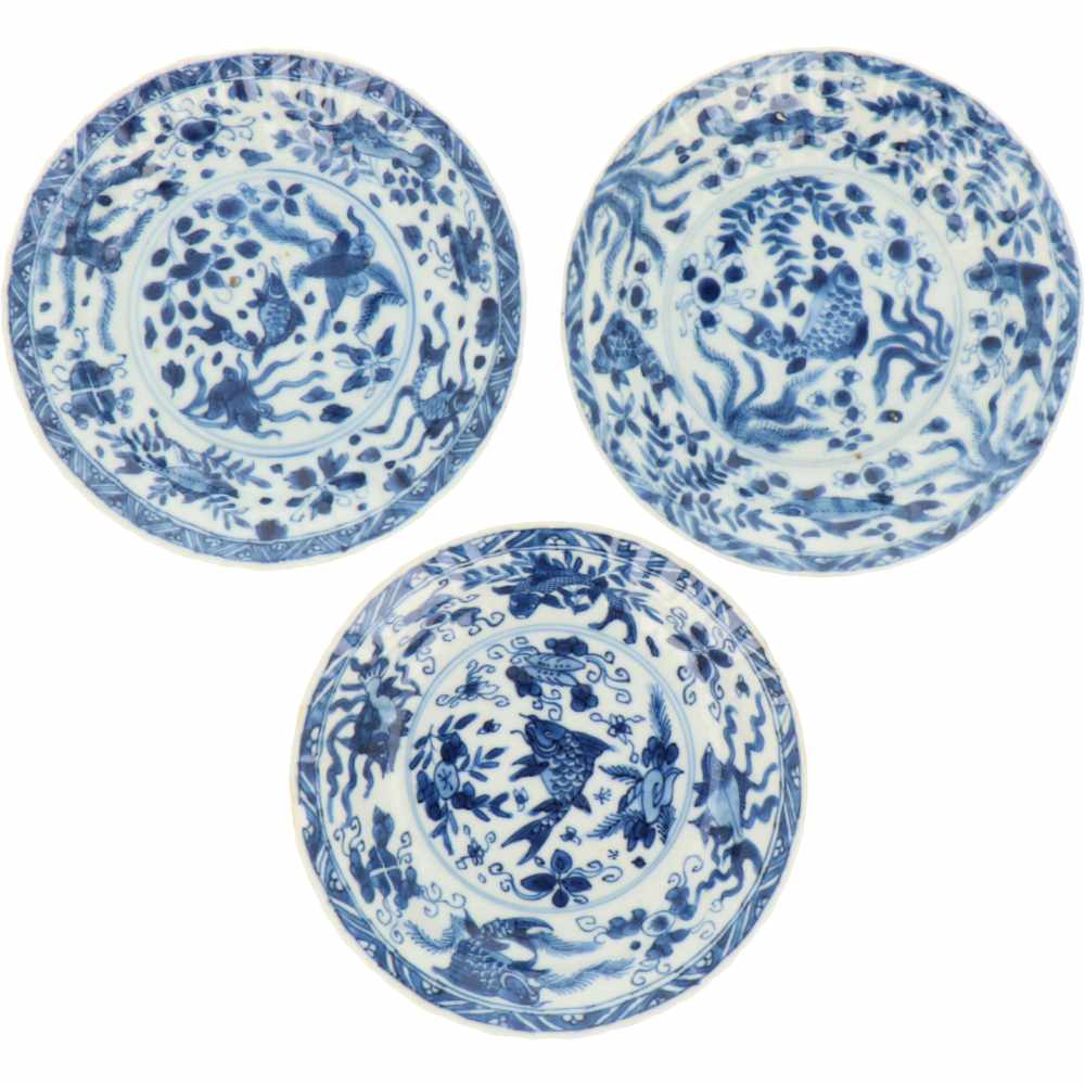 Een set van drie porseleinen bordjes met vissen decor, gemerkt met Conische schelp. China, Kangxi.