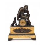 A bronze and marble mantle clock with a sculpture of a resting hunter with his dog. France, 19th