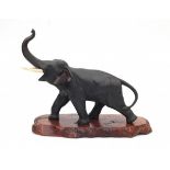 A Japanse bronze sculpture, elephant with ivory tusks on wooden base. Marked with a sealmark,