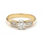 A 18 krt yellow gold solitaire ring. Set with a brilliant cut diamond and two trapezium cut diamonds