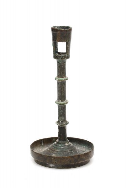 A bronze saucer candlestick, the stem with four decorative discs. Presumably Spain, 17th century.
