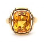 A 14 krt yellow gold ring. 1960's. Set with a cushion cut yellow sapphire, ca. 10.67 ct. Gross