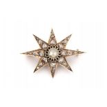 A 14 krt yellow gold star brooch. Late 19th - early 20th century. Set with rose cut diamonds.