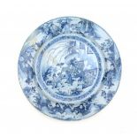 A blue and white Delftware charger, decorated with a group of boys in garden, the rim with a