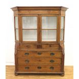 An oak porcelain cabinet, the top with glazed door and the bottom section with five drawers. 19th