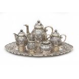 A Djokja silver tea set decorated with stylized flowers. The set comprises of; a teapot, lidded